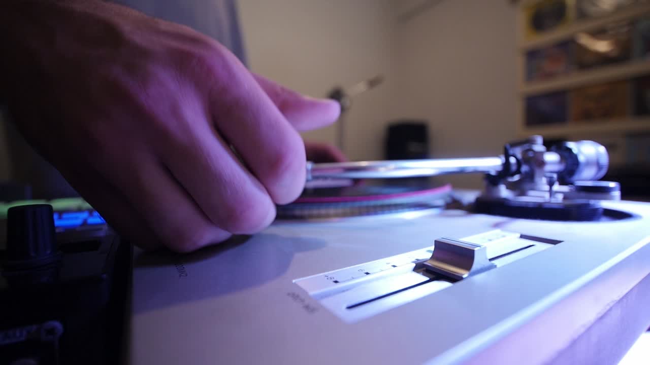 dj moviendo el lápiz óptico en vinilo para reproducir diferentes pistas en el tocadiscos manos ultra anchas de cerca