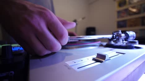 dj moving stylus on vinyl to play different track on turn table ultra wide hands close up