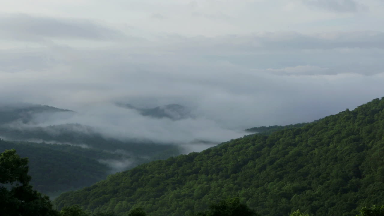Pan across misty green mountains.
