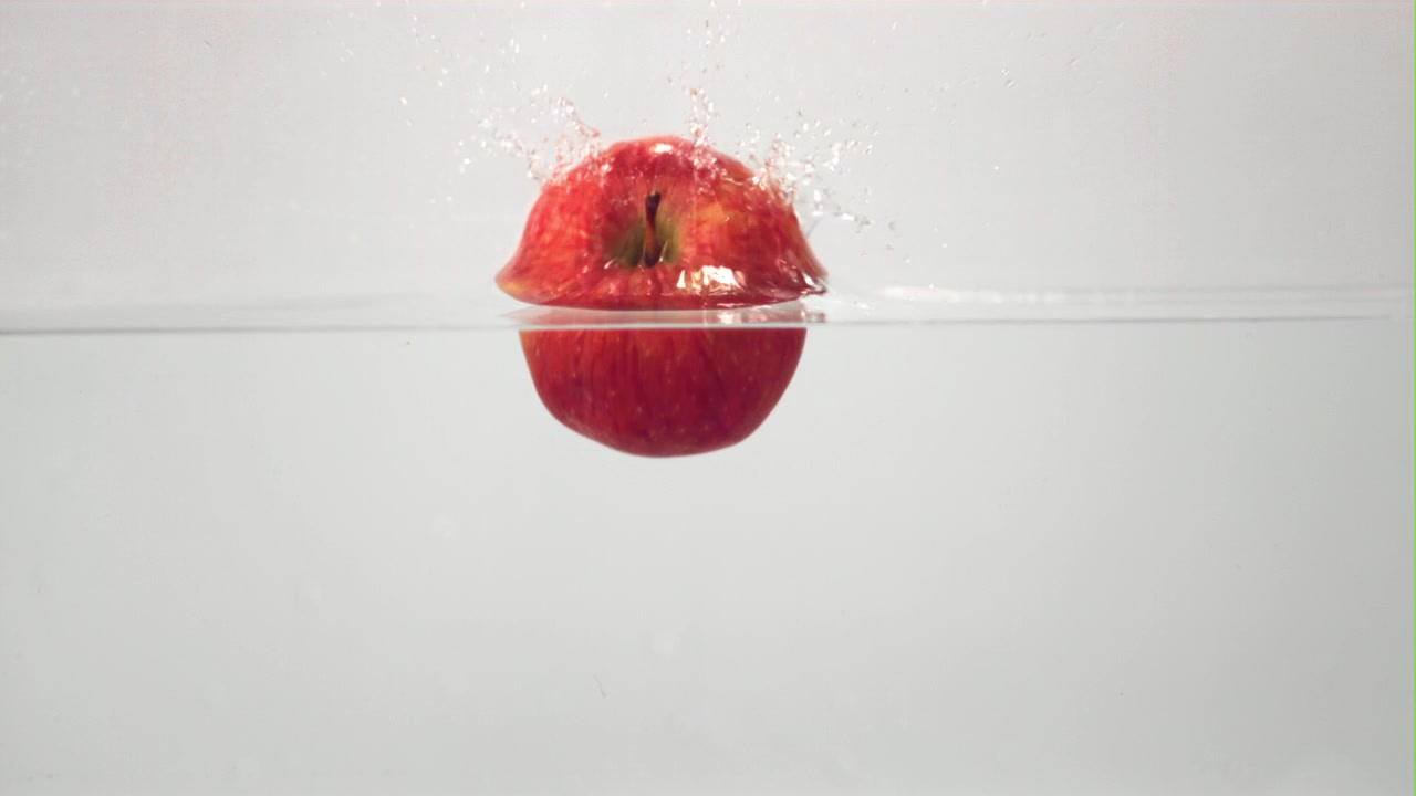 Slow Motion of a Red Apple Dropping into Water