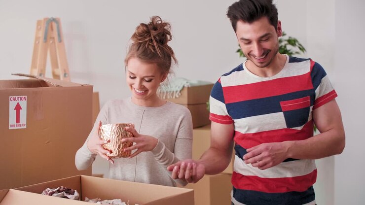 Loving couple packing stuff to cartons
