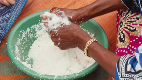 traditional food preparation, hands kneading coconut snow making cocos milk in a bowl