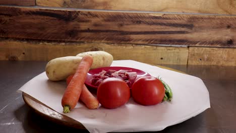 Wide-shot-of-spinning-lazy-susan-with-carrots,-potatoes,tomatoes,-green-beans-and-meat