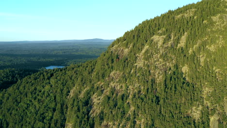 Drohnenaufnahme-Aus-Der-Luft,-Die-über-Einen-Kamm-Auf-Dem-Bohrberg-über-Dichten-Grünen-Waldbäumen-Und-Einem-Blauen-See-In-Der-Wildnis-Von-Maine-Fliegt