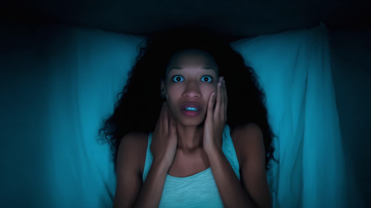 A Woman Awakens in Fear: Capturing the Intensity of Anxiety at Night with Wide-Eyed Shock and a Genuine Expression of Panic in a Dimly Lit Room