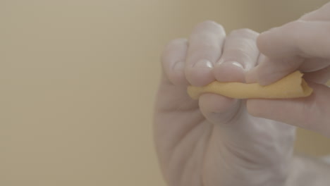 cerca de las manos apretando la cáscara de una naranja la liberación de pequeñas gotas de jugo en cámara lenta para un tronco de cóctel