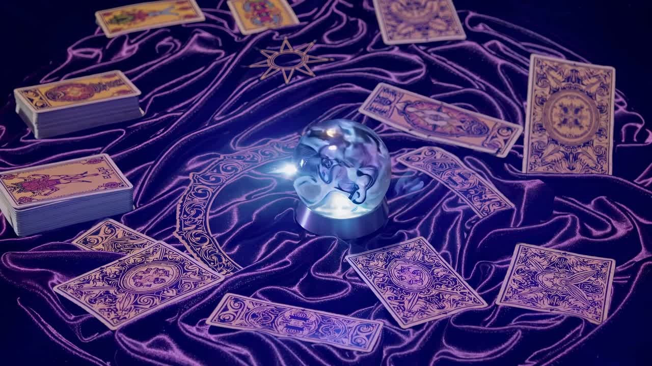 Overhead shot of a mystical setup with tarot cards and a glowing crystal ball on a purple cloth