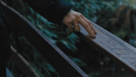 close up hands woman walking on wooden bridge in forest enjoying nature exploring natural outdoors