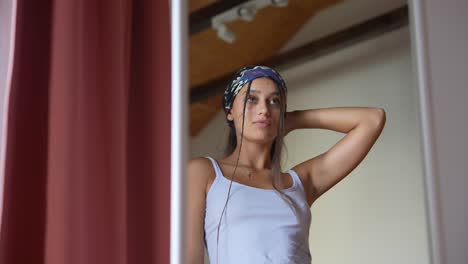 mujer estilizando su cabello delante de un espejo
