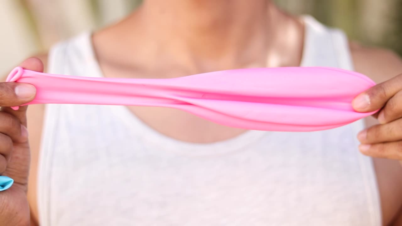 클로즈업 에서 큰 분홍색 풍선을 펴고 있는 알 수 없는 사람