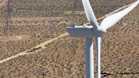 Vista-Aérea-De-Las-Palas-Giratorias-De-Una-Turbina-Eólica-En-El-Desierto-De-Mojave-En-Un-Día-Soleado