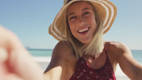 Caucasian-woman-sending-kisses-through-camera-at-beach