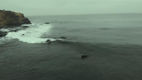 Antena-De-Surfista-Montando-Una-Ola-Esquivando-Rocas-En-Un-Día-Frío-En-Pichilemu,-Chile-4k