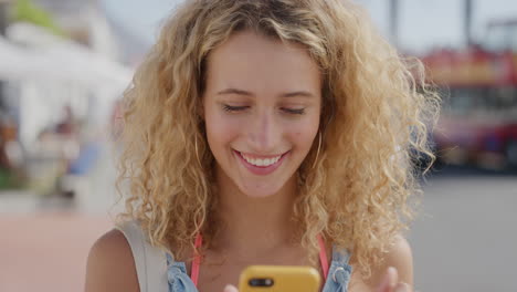 portrait of happy beautiful blonde woman using smartphone enjoying texting browsing on summer vacation sharing experience online attractive female tourist beachfront