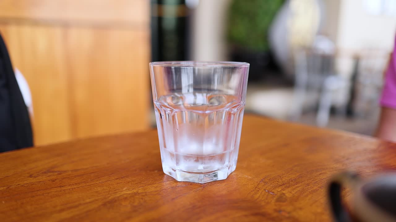 Acqua versata in un bicchiere su un tavolo