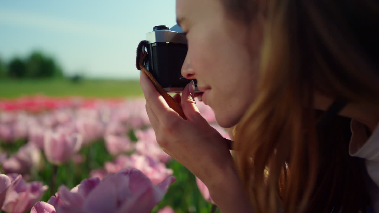 Primo piano del profilo di una donna che fotografa un fiore. Ritratto di donna che scatta una foto.