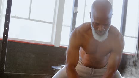 Senior-man-rubbing-white-powder-on-his-hand-before-workout-4k