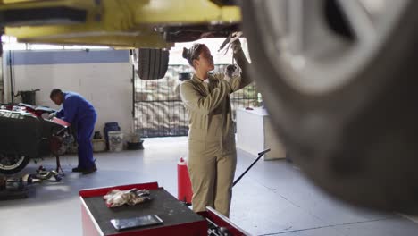 video of biracial female car mechanic repairing car