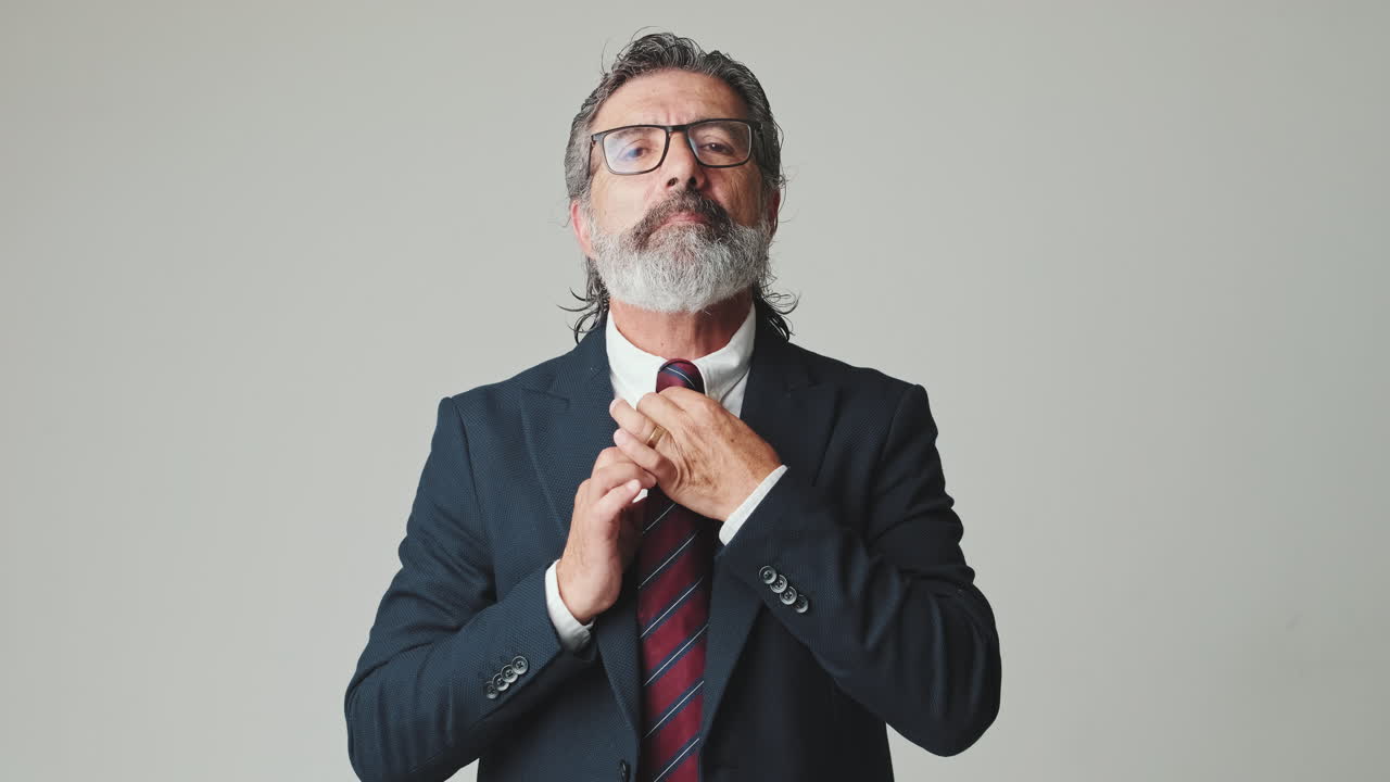 Mature Businessman in Suit Adjusting His Tie