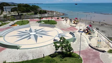 Rising-aerial-drone-of-newly-built-kids-playground,-city-and-the-ocean-in-Dili,-Timor-Leste,-South-East-Asia