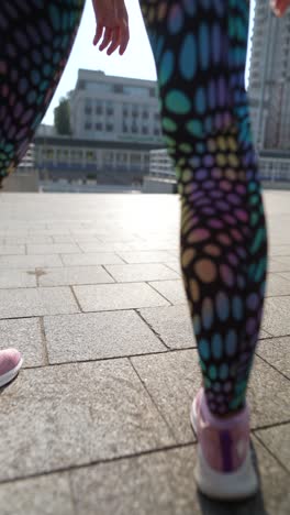 woman stretching on city sidewalk