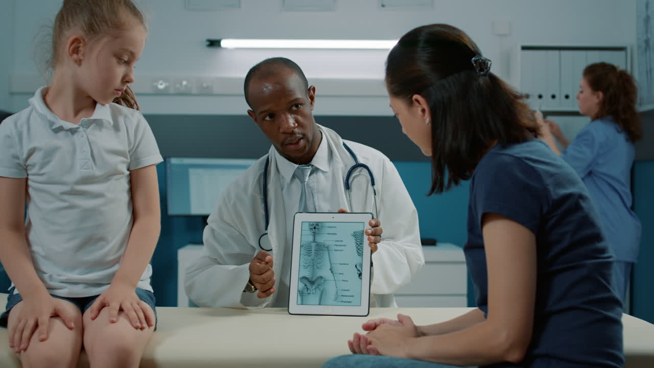 Doctor Explaining X-Ray Results to Child and Mother