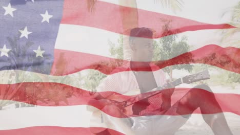 Animation-of-waving-flag-of-america-over-african-american-man-playing-guitar-on-beach