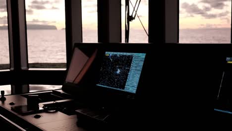 navigational equipment on the bridge of a motor yacht while underway and steaming at sunset