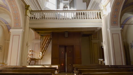 an inside tilting up of view with the center chandelier of a catholic church, having beautiful and antique art work