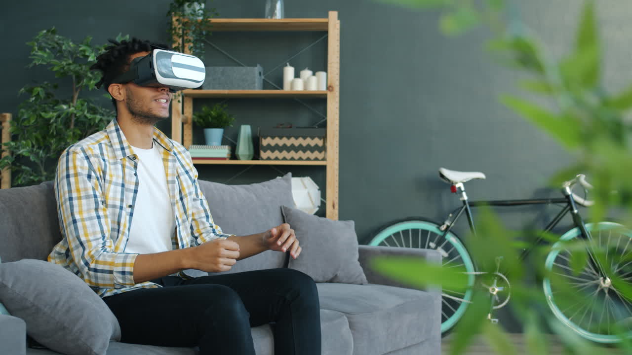 Uomo con visore VR sul divano