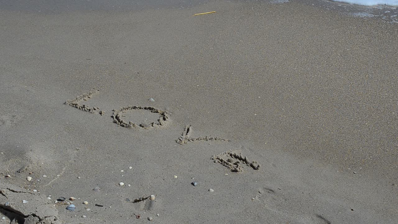 Mot amour. Le mot amour, emporté par une vague.