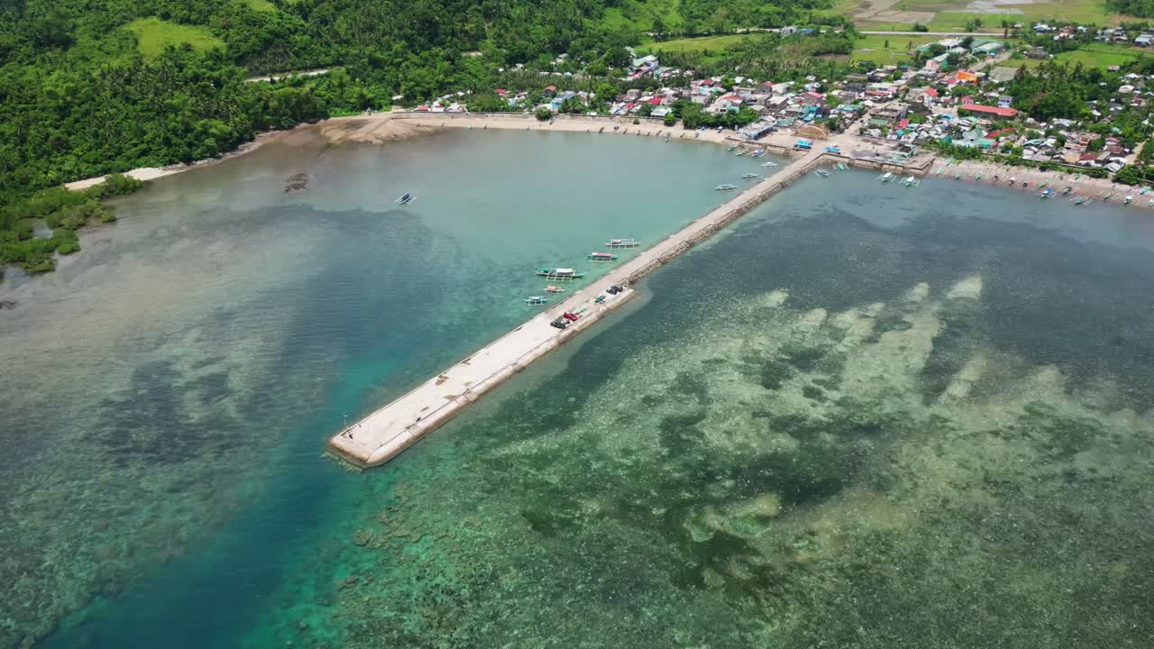 Vibrant aerial hyperlapse of coastal fishermen village and port with traditional bangka boats docked during daytime - Codon, Catanduanes, Philippines