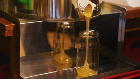 pouring fresh linden honey into jar