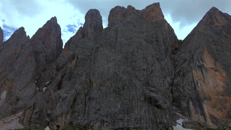 close-up aerial view of the steep, towering rocky peaks in the dolomites, italy, highlighting their rugged texture under a dramatic sky