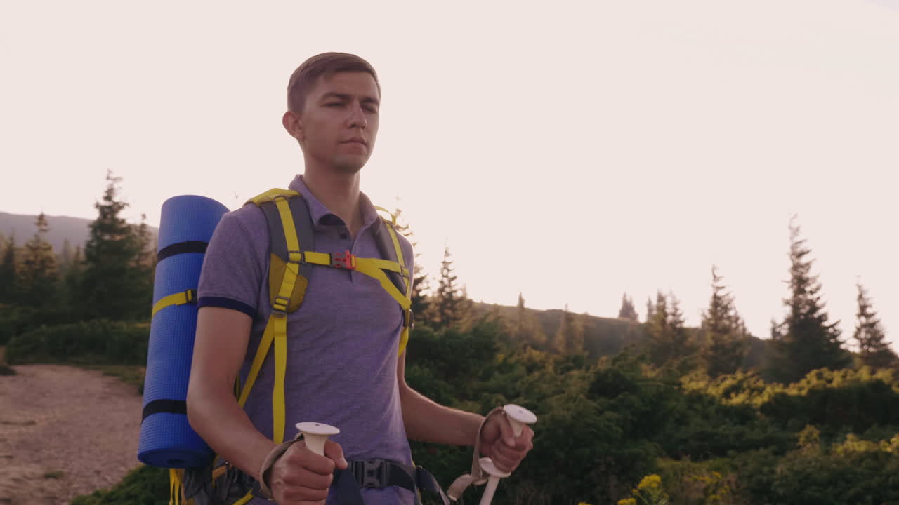 un joven turista sube a la montaña usa bastones de trekking en el contexto de un pintoresco s