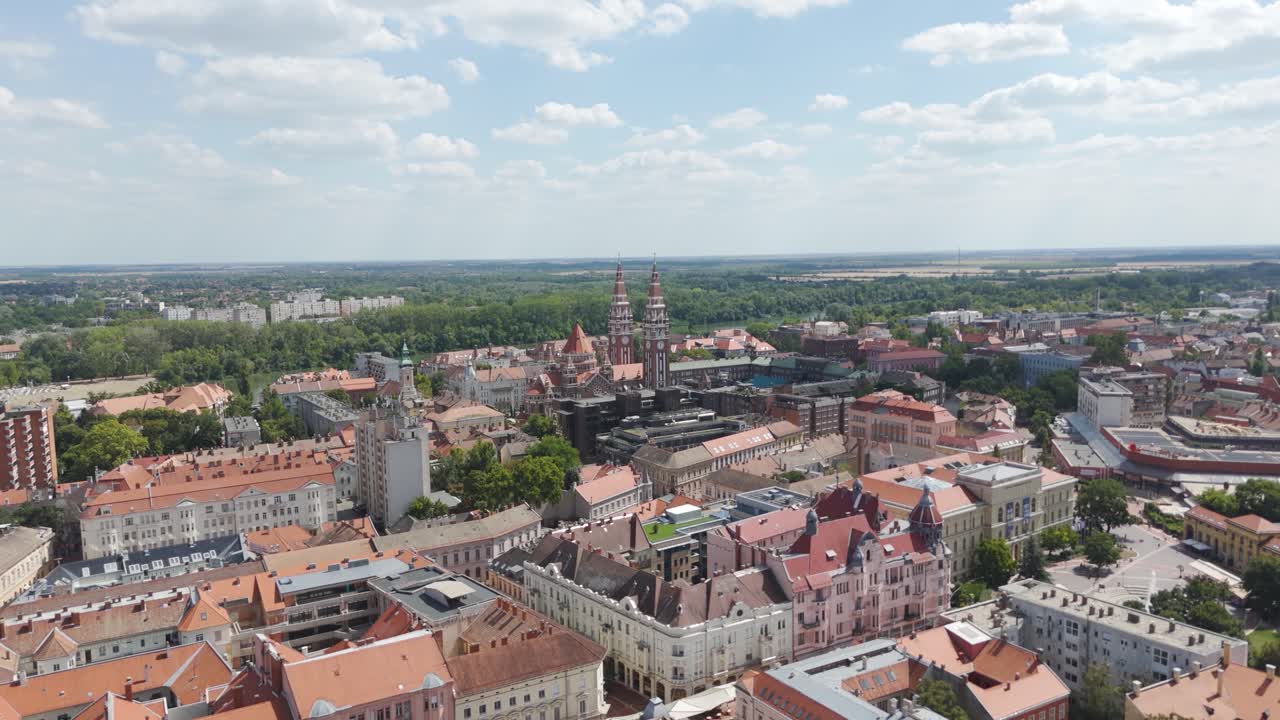 Vista aerea del paesaggio urbano di Seghedino con la chiesa votiva visibile in lontananza, che mette in risalto tetti, strade e architettura storica