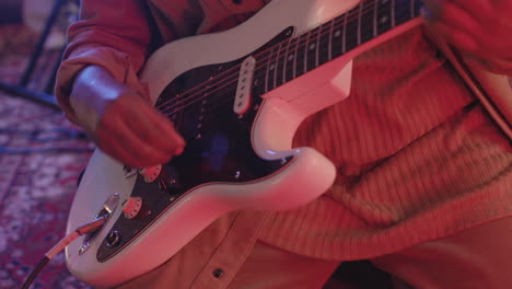 close up of an unrecognizable musician playing electric guitar in recording studio 1