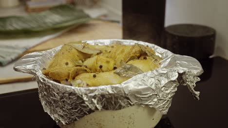 uncovering foil paper from a freshly steamed chicken thighs