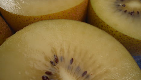 Amazing-close-up-rotating-yellow-kiwi-fruits,-juicy-tropical-exotic-fruit,-4K-macro-shot