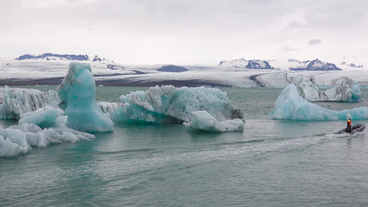 jokulsarlon iceland 1의 녹는 빙하 석호에서 조디악 보트가 빙산을 통과합니다.