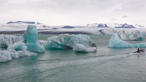 a zodiac boat makes its way through icebergs in a melting glacier lagoon at jokulsarlon iceland 1