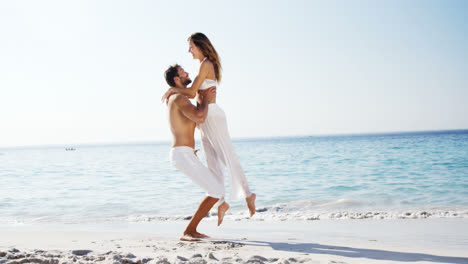 mujer corriendo hacia el hombre y saltando en sus brazos en la playa 4k