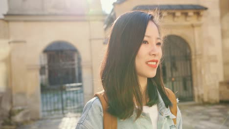 Portrait-Of-The-Beautiful-Young-Woman-With-Red-Lips-Turning-Her-Face-To-The-Camera-And-Smiling-Happily-While-Having-Sightseeing-Roung-The-City-On-A-Sunny-Day