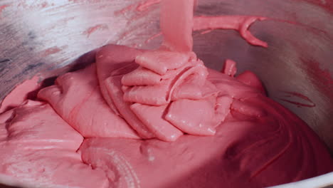 mixing pink dough in a bowl