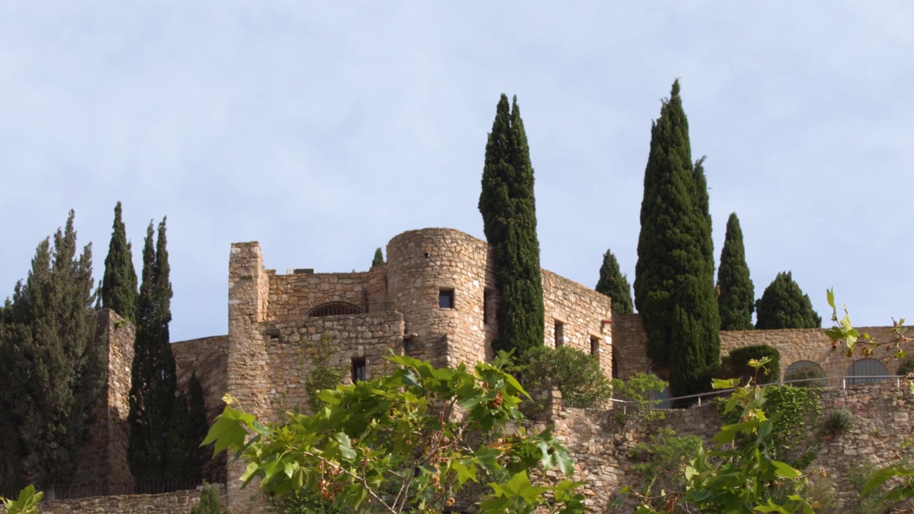 Inquadratura ampia statica della storica fortezza in pietra e dei cipressi a Cassis, Francia.