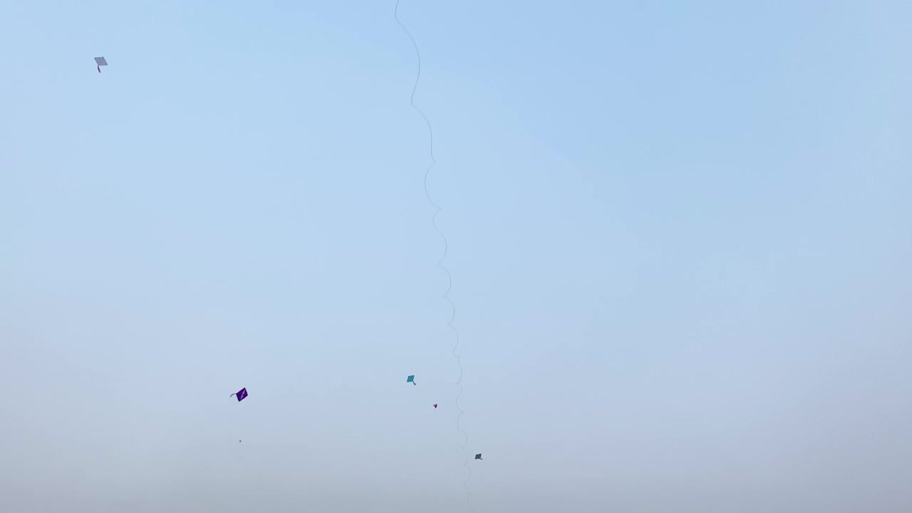 Aquiloni che volano nel cielo, aquiloni di carta tradizionali che volano in alto durante un festival, cielo azzurro limpido e aperto, Asia meridionale, di giorno, inquadratura statica dal basso, luogo esterno.