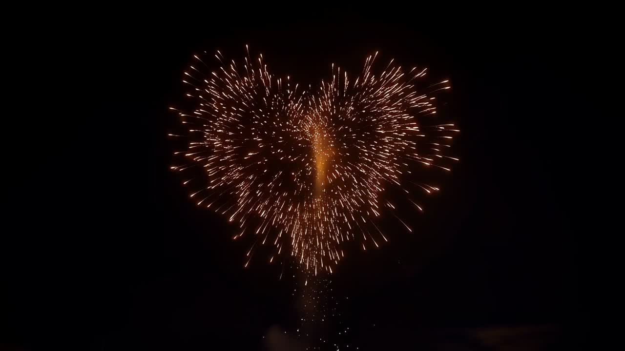 Razzo che si alza da terra e si dirige verso il cielo notturno, esplodendo in una forma a cuore e lasciando una scia di fumo