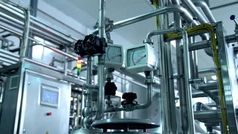 modern technological equipment at the milk plant. pipes with sensors leading to the tanks and engine. close up.