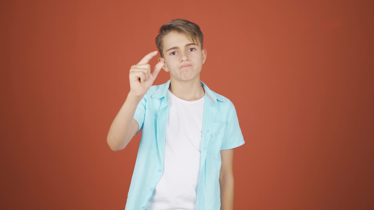 el niño haciendo el pequeño signo con su mano.