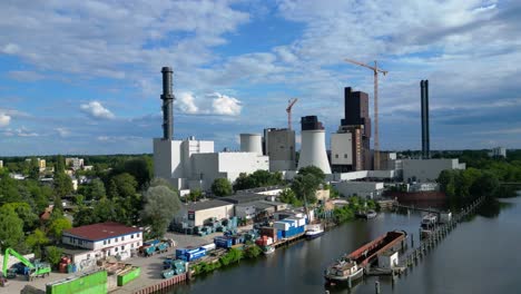 power plant undergoing conversion, retrofitting and renewal, featuring cooling towers, chimneys, and construction crane. magic aerial view flight ascending drone